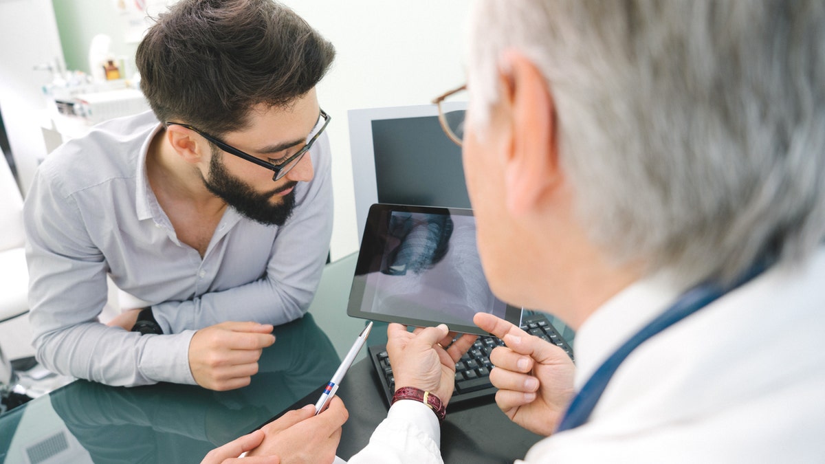 Mature doctor using a digital tablet for his diagnosis.