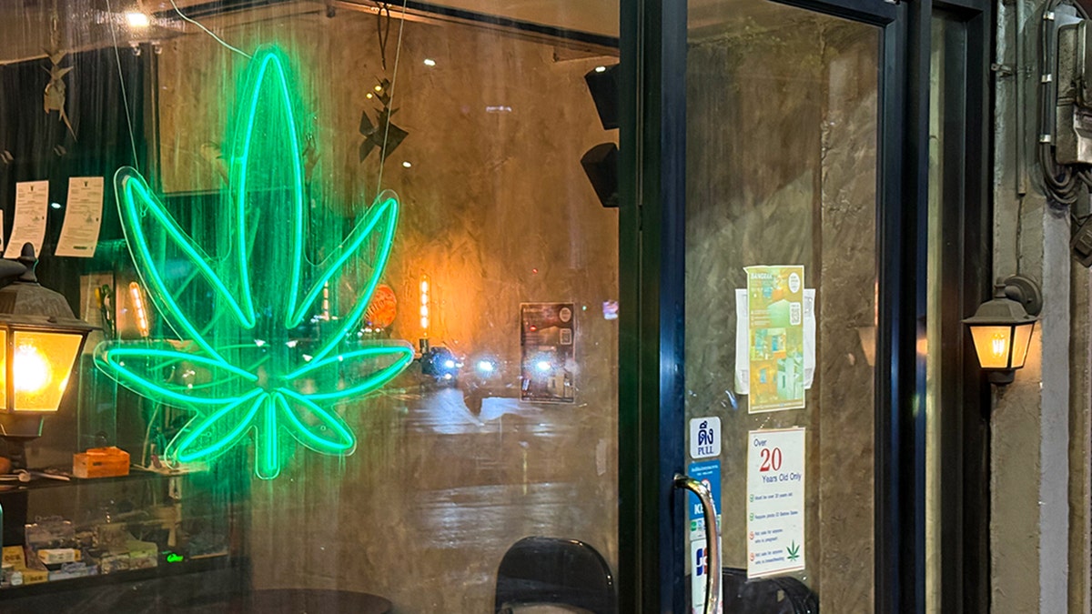 Cannabis store with neon leaf sign in window