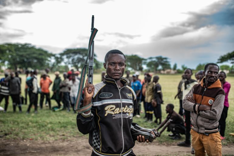 UVIRA, DEMOCRATIC REPUBLIC OF CONGO - DECEMBER 15: A Wazalendo militant surrenders a weapon to members of the Rwanda-backed M23 rebel group on December 15, 2025 in Uvira, Democratic Republic of Congo. Fifty-two members from the coalition of Congolese and Burundian militias known as the Wazalendo joined M23 following the rebels' capture of the South Kivu city on December 10. Human Rights Watch has reported abuses perpetrated against civilians by fighters from both sides of the conflict during the offensive on Uvira, and has called for the safe passage and humanitarian assistance for those caught up in the fighting. (Photo by Daniel Buuma/Getty Images)