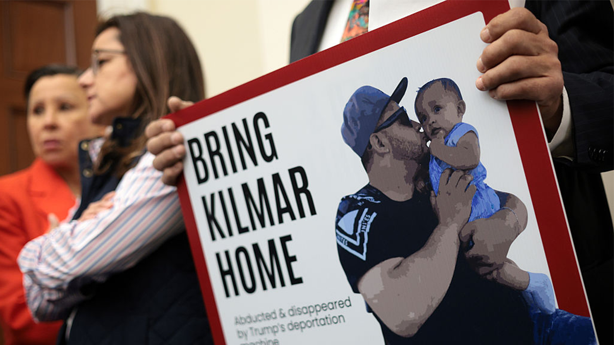 A member of the Congressional Hispanic Caucus holds a picture of Kilmar Abrego Garcia during a news conference.