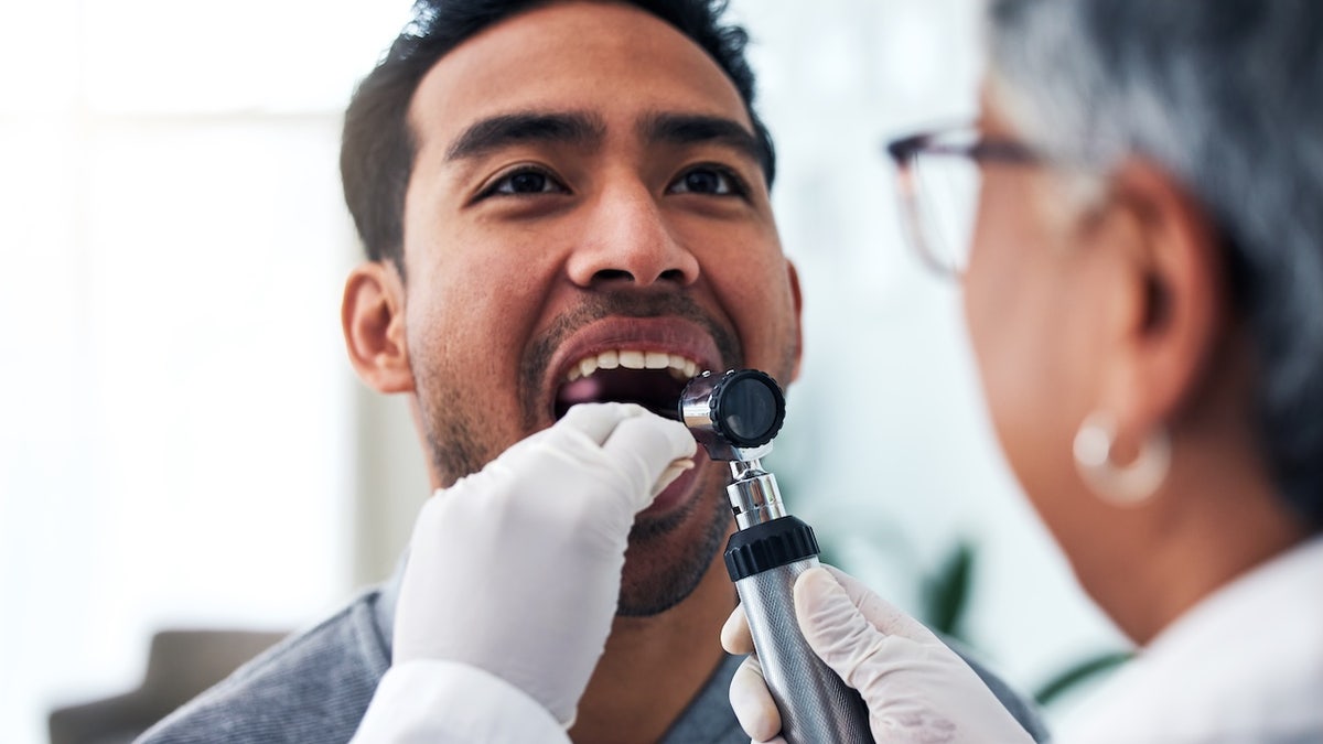 Man at doctor getting mouth exam