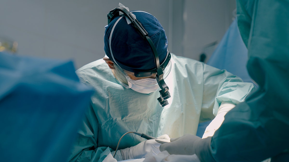 Surgeon using medical instruments in surgery.