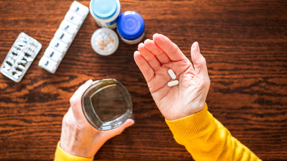 Woman holding two pills